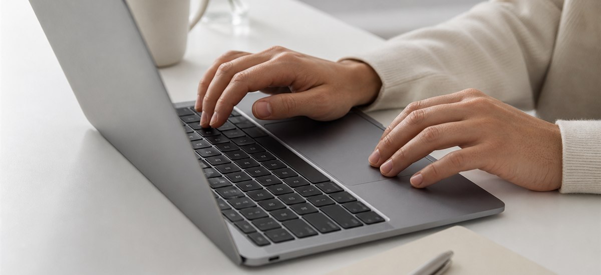 Hands typing on a MacBook during setup